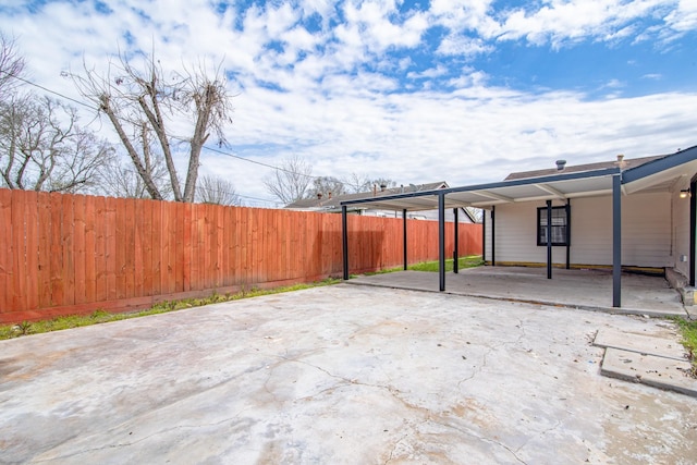 view of patio with a carport and fence