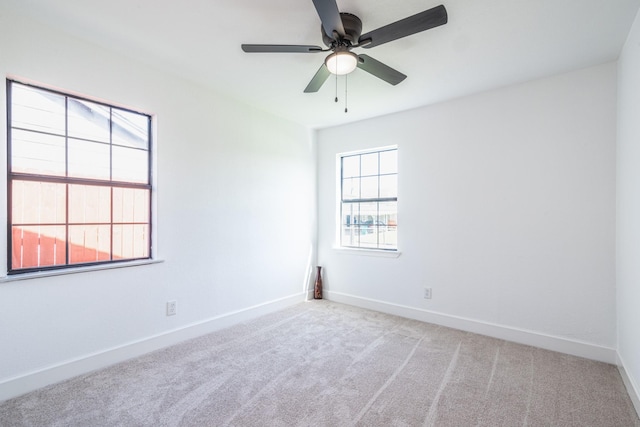 spare room with carpet floors, baseboards, and a ceiling fan