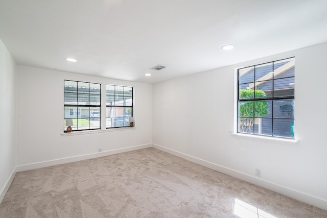 unfurnished room with carpet floors, recessed lighting, visible vents, and baseboards