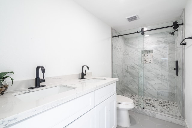 bathroom featuring a marble finish shower, visible vents, a sink, and toilet