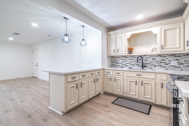 kitchen with a peninsula, stainless steel electric range, a sink, and light wood-style floors