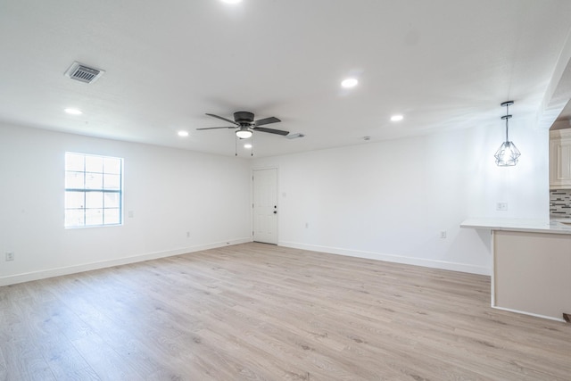 empty room with baseboards, light wood-type flooring, visible vents, and recessed lighting