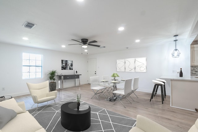 living area with light wood-style flooring, visible vents, and recessed lighting