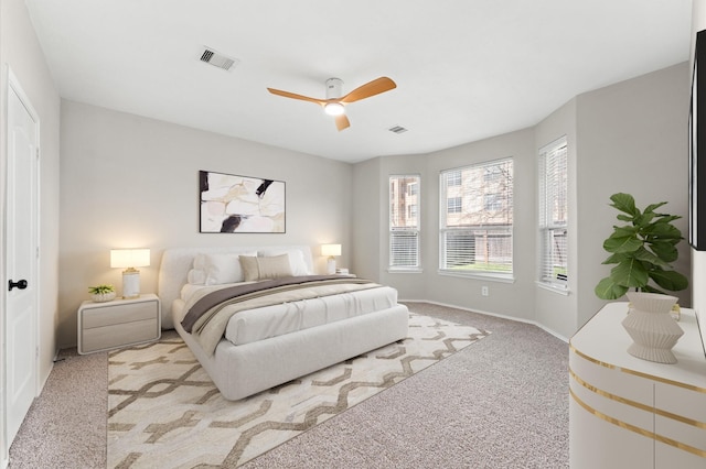 carpeted bedroom featuring baseboards, visible vents, and a ceiling fan