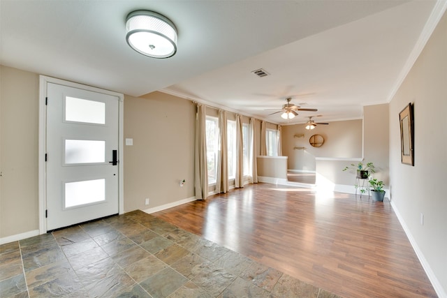 entryway with ceiling fan, wood finished floors, visible vents, baseboards, and crown molding