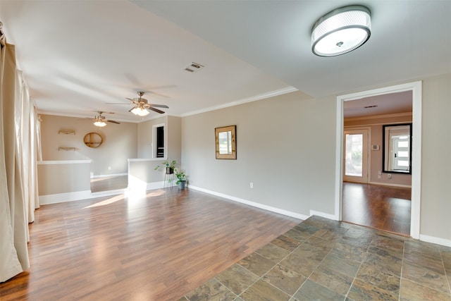 unfurnished living room with baseboards, visible vents, ceiling fan, wood finished floors, and crown molding