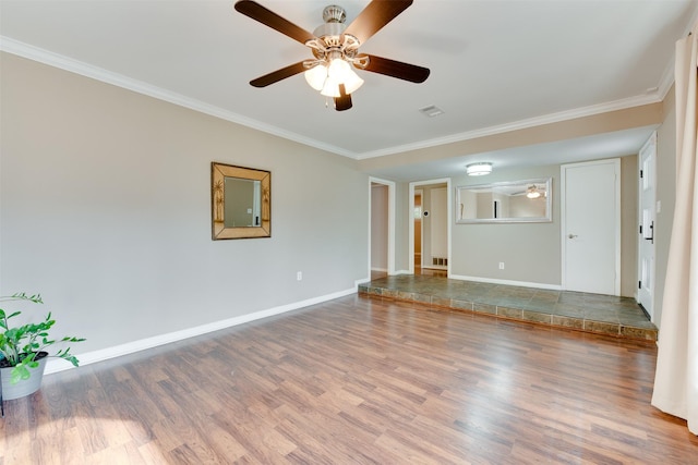 unfurnished room with crown molding, baseboards, and wood finished floors