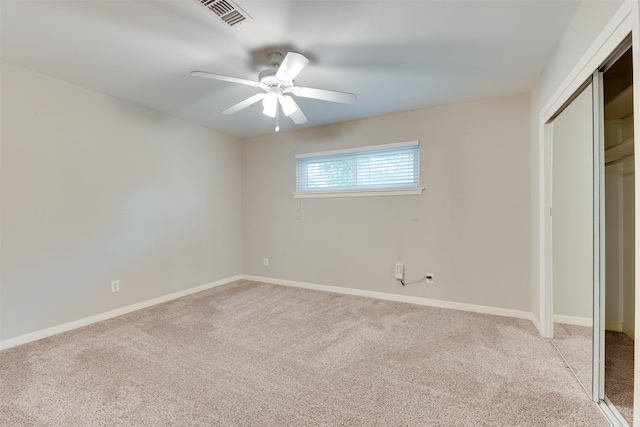 unfurnished bedroom featuring ceiling fan, visible vents, baseboards, a closet, and carpet