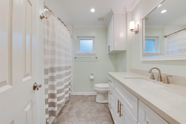 bathroom featuring toilet, vanity, baseboards, visible vents, and crown molding