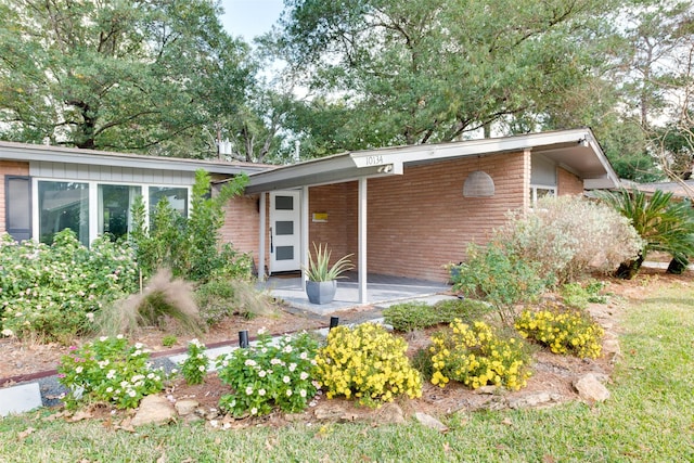 mid-century modern home featuring brick siding and an attached carport