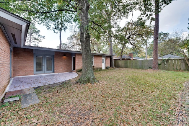 view of yard with french doors, a patio area, and fence