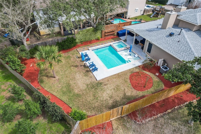 view of pool featuring a yard, a fenced backyard, a pool with connected hot tub, and a patio