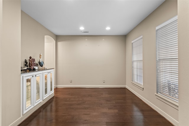 bar featuring arched walkways, recessed lighting, visible vents, baseboards, and dark wood-style floors