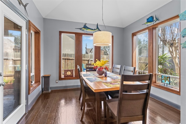 dining area featuring dark wood-style floors, lofted ceiling, and baseboards