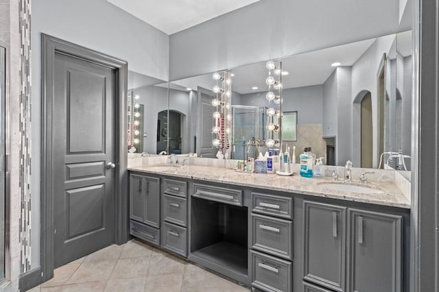 full bath featuring double vanity, tile patterned flooring, a sink, and a shower with shower door