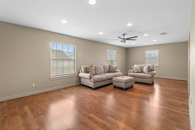 living room featuring baseboards, visible vents, a ceiling fan, light wood-type flooring, and recessed lighting