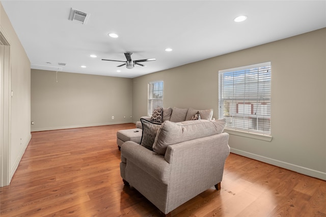 living area featuring visible vents, a wealth of natural light, light wood-type flooring, and attic access