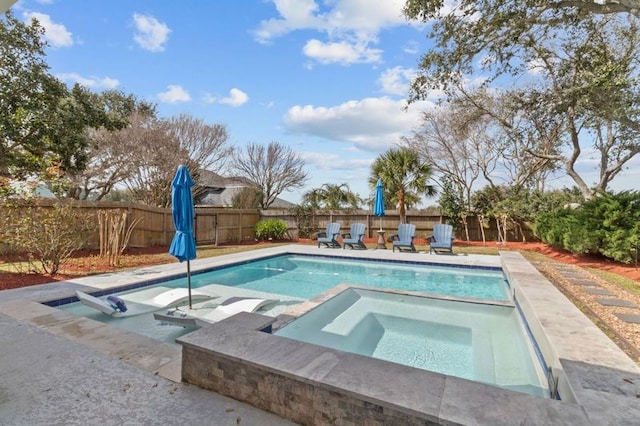 view of swimming pool featuring a fenced backyard and an in ground hot tub