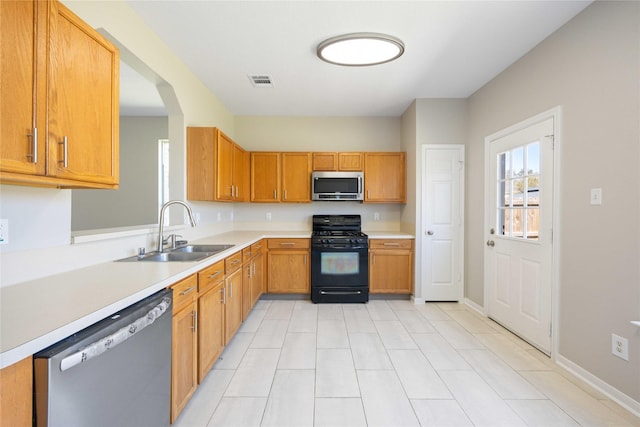 kitchen featuring light countertops, visible vents, appliances with stainless steel finishes, a sink, and baseboards