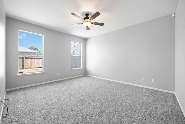 empty room with baseboards, a ceiling fan, and carpet flooring