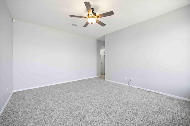 carpeted spare room with a ceiling fan, visible vents, and baseboards