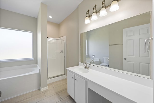 bathroom with a stall shower, toilet, vanity, wood finish floors, and a bath