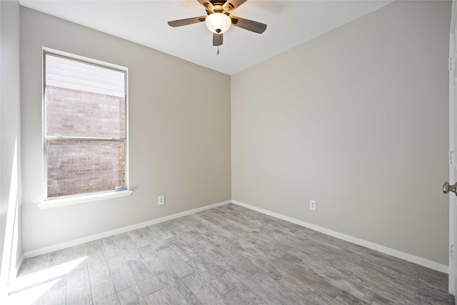 empty room with ceiling fan, wood finished floors, and baseboards