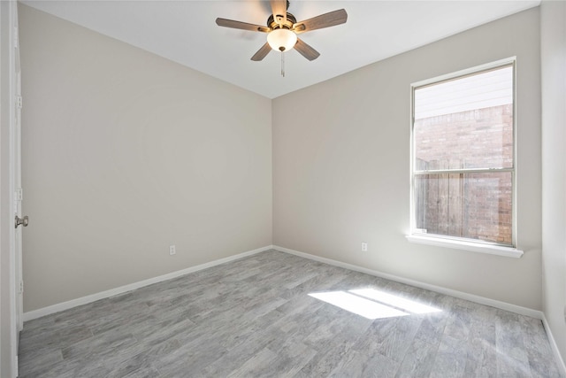 empty room featuring a ceiling fan, baseboards, and wood finished floors