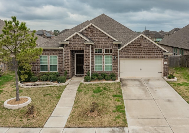 view of front of property featuring an attached garage, roof with shingles, a front lawn, and brick siding