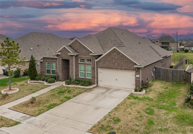 view of front of property featuring a front yard, brick siding, fence, and an attached garage