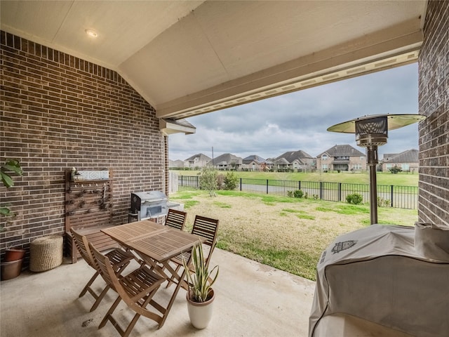 view of patio featuring a grill, a residential view, a fenced backyard, and outdoor dining space