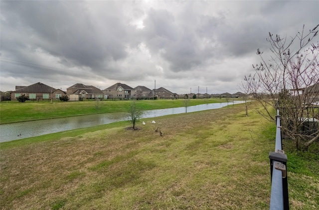 exterior space with a residential view, a water view, and a lawn