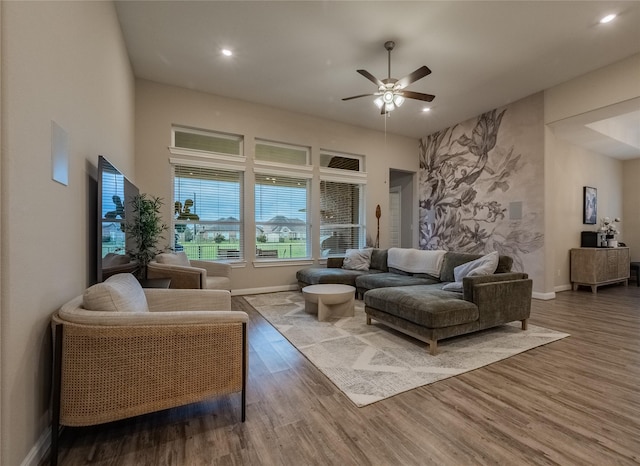 living room featuring a ceiling fan, baseboards, wood finished floors, and recessed lighting