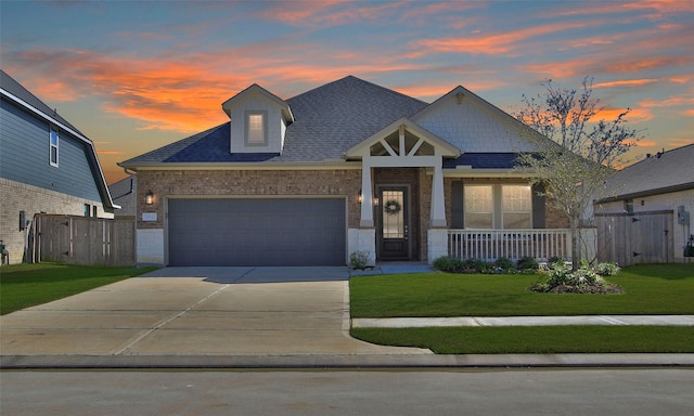 craftsman house with a shingled roof, a porch, a lawn, a garage, and driveway