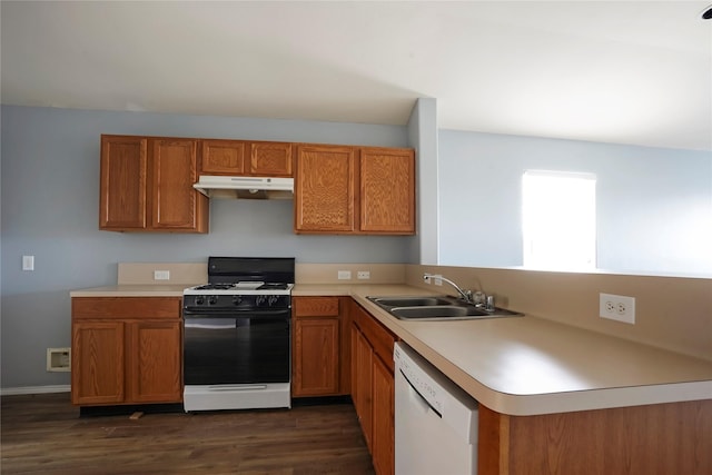 kitchen featuring under cabinet range hood, a sink, brown cabinetry, dishwasher, and gas range oven