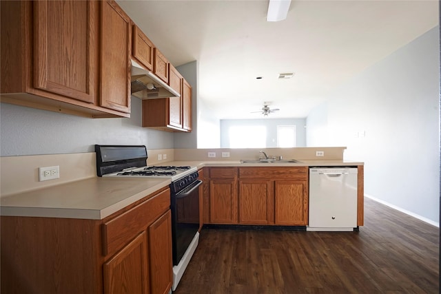 kitchen with white dishwasher, a sink, gas range, under cabinet range hood, and a peninsula