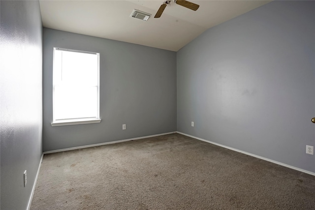 empty room featuring lofted ceiling, visible vents, baseboards, a ceiling fan, and carpet