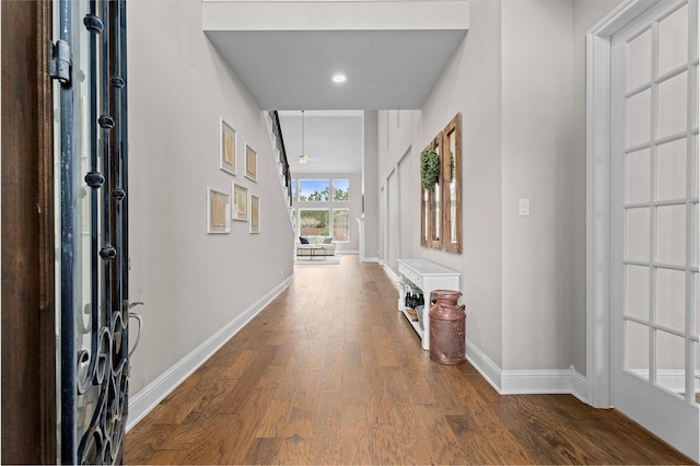 corridor featuring baseboards and wood finished floors