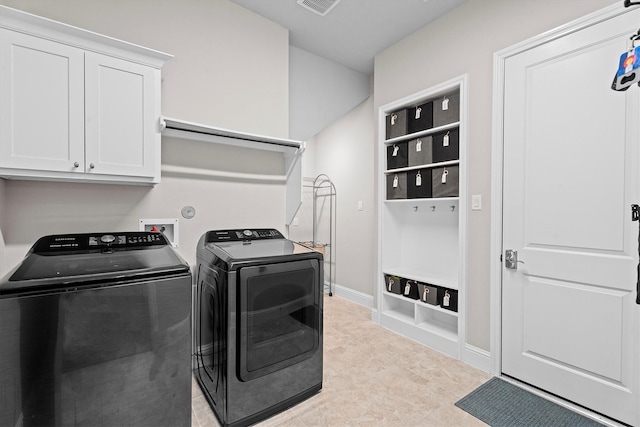 laundry room with light tile patterned floors, washing machine and dryer, visible vents, baseboards, and cabinet space