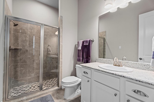 bathroom with a stall shower, vanity, and toilet