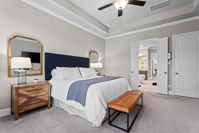 bedroom with a tray ceiling, visible vents, crown molding, and light carpet