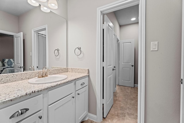 ensuite bathroom featuring ensuite bath, tile patterned flooring, baseboards, and vanity