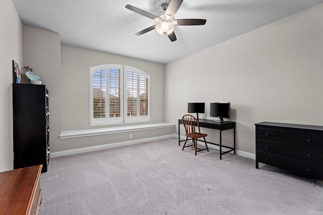 carpeted office featuring ceiling fan and baseboards