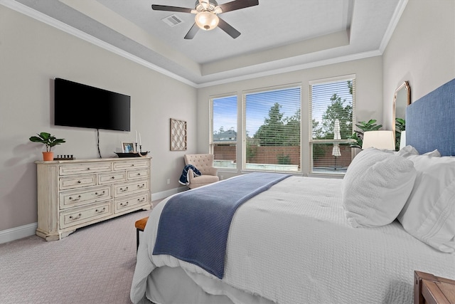 bedroom with a tray ceiling, baseboards, visible vents, and carpet