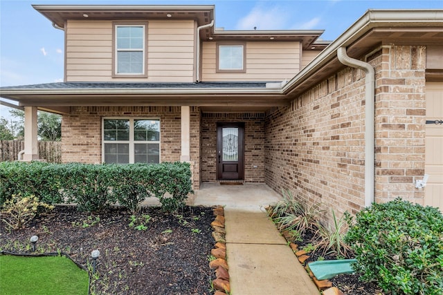 entrance to property with brick siding and an attached garage