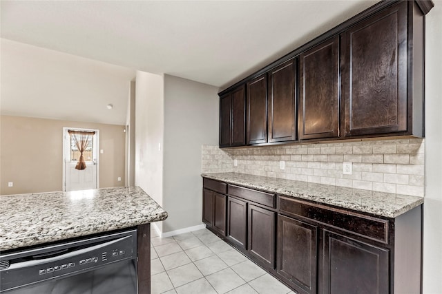 kitchen featuring black dishwasher, dark brown cabinets, light stone counters, and decorative backsplash