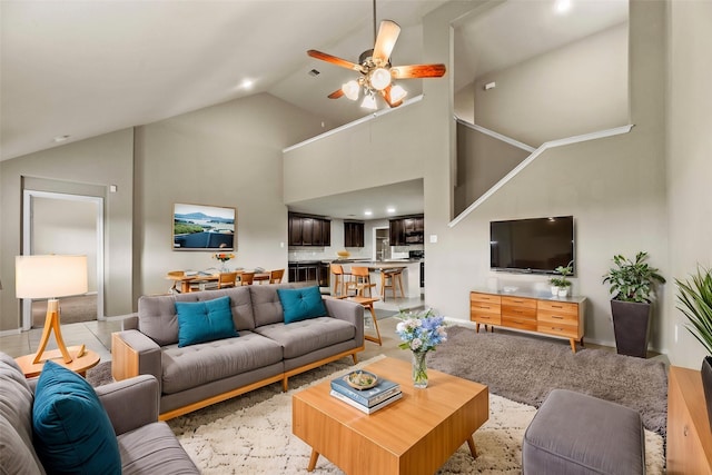 living area featuring high vaulted ceiling, ceiling fan, and baseboards