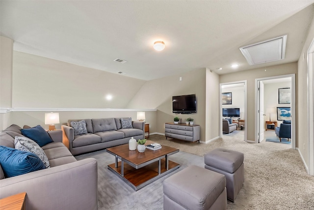 carpeted living room with attic access, visible vents, vaulted ceiling, and baseboards