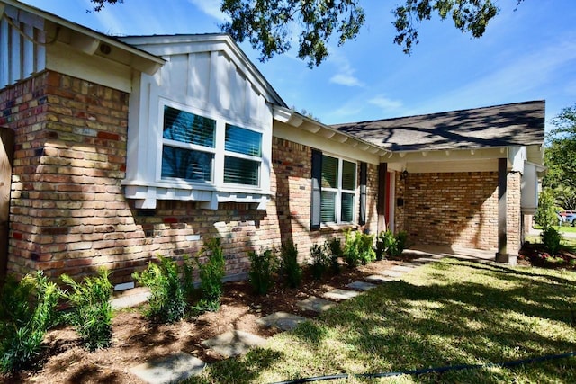 view of property exterior with a lawn and brick siding