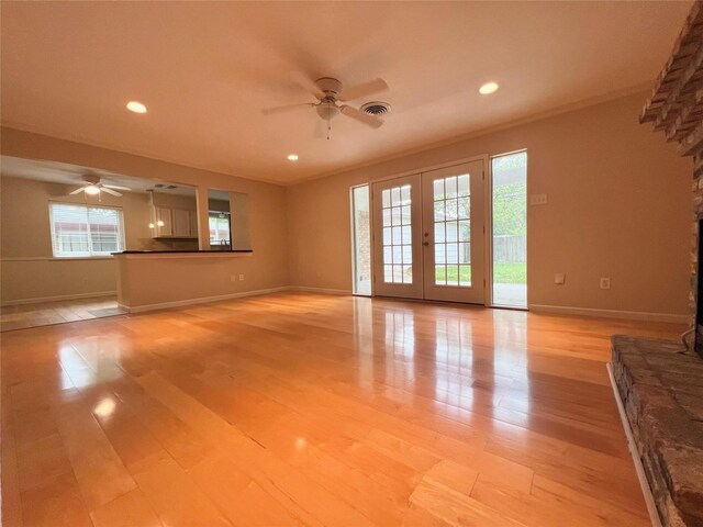 unfurnished living room with ceiling fan, french doors, visible vents, and light wood-style floors